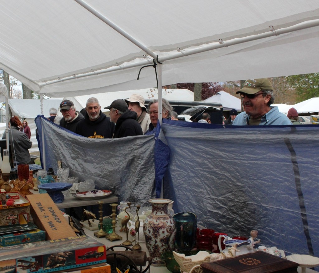 It’s a peep show at many dealer tents before the noon opening bell. Here the rubberneckers peer in to a collection of toys being offered by Park City Auction, Bridgeport, Conn. —Hertan’s