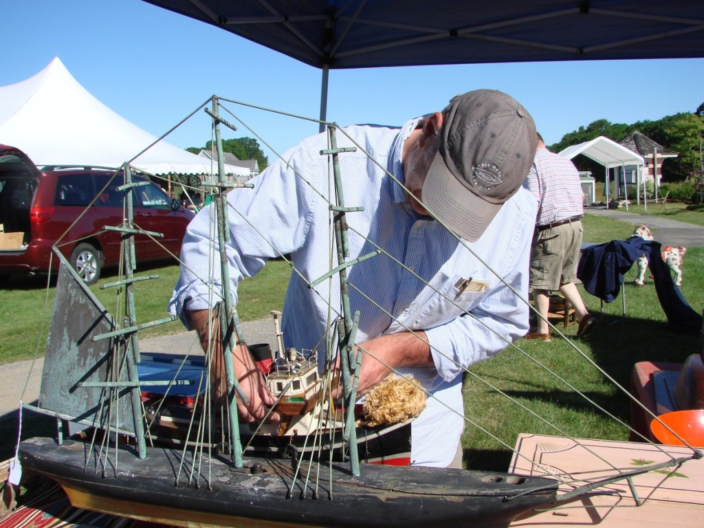 John Marshall, Florence, Mass., was putting the finishing touches on his display before the show opened. The ship weathervane was priced at $2,500, and the wooden tugboat was $950.