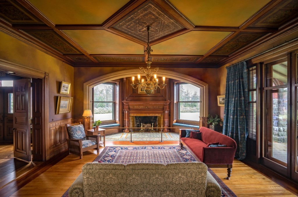 The large parlor was the main living room as well as a space to receive and entertain guests. The intricately carved fireplace surround is the focal point. Glass doors to the right provide light as well as easy access to the lawn and garden.