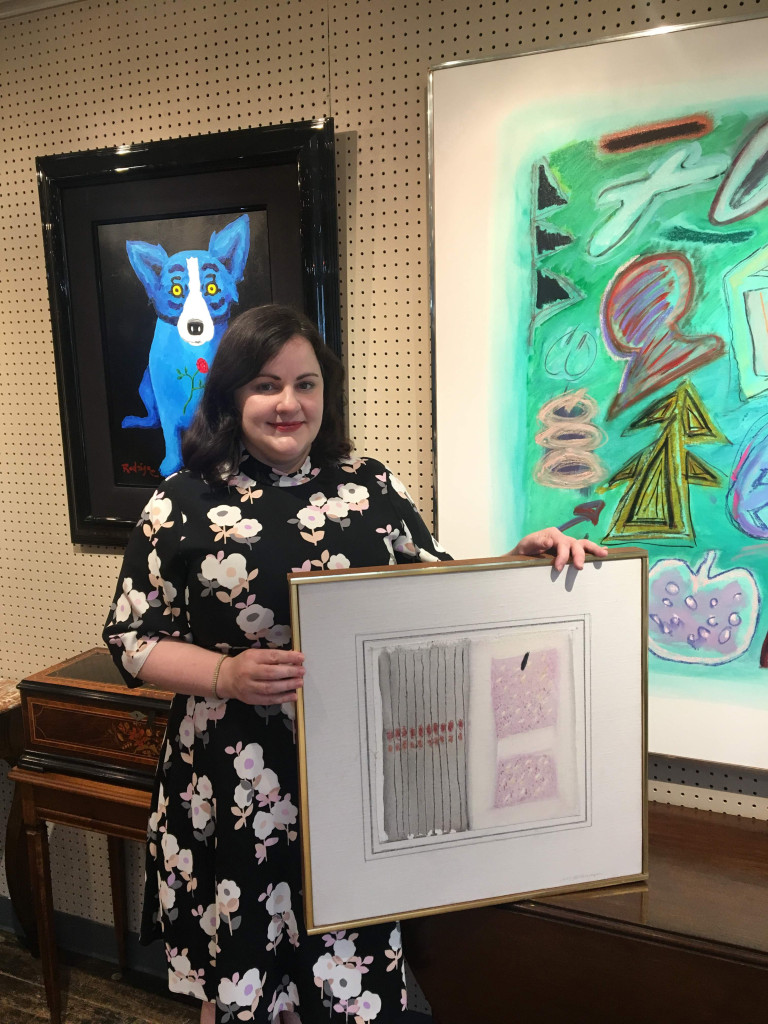 Marney Robinson, head of Neal’s painting department, shows off the stars of Twentieth Century painting. At right, top lot of the July sale, Kohlmeyer’s “Semiotic 86-6” sold for $36,600; in front, the artist’s “Collage 79-6,” brought $10,370. At left, George Rodrigue’s “Deep Love,” a 1998 Blue Dog painting, realized $34,160.