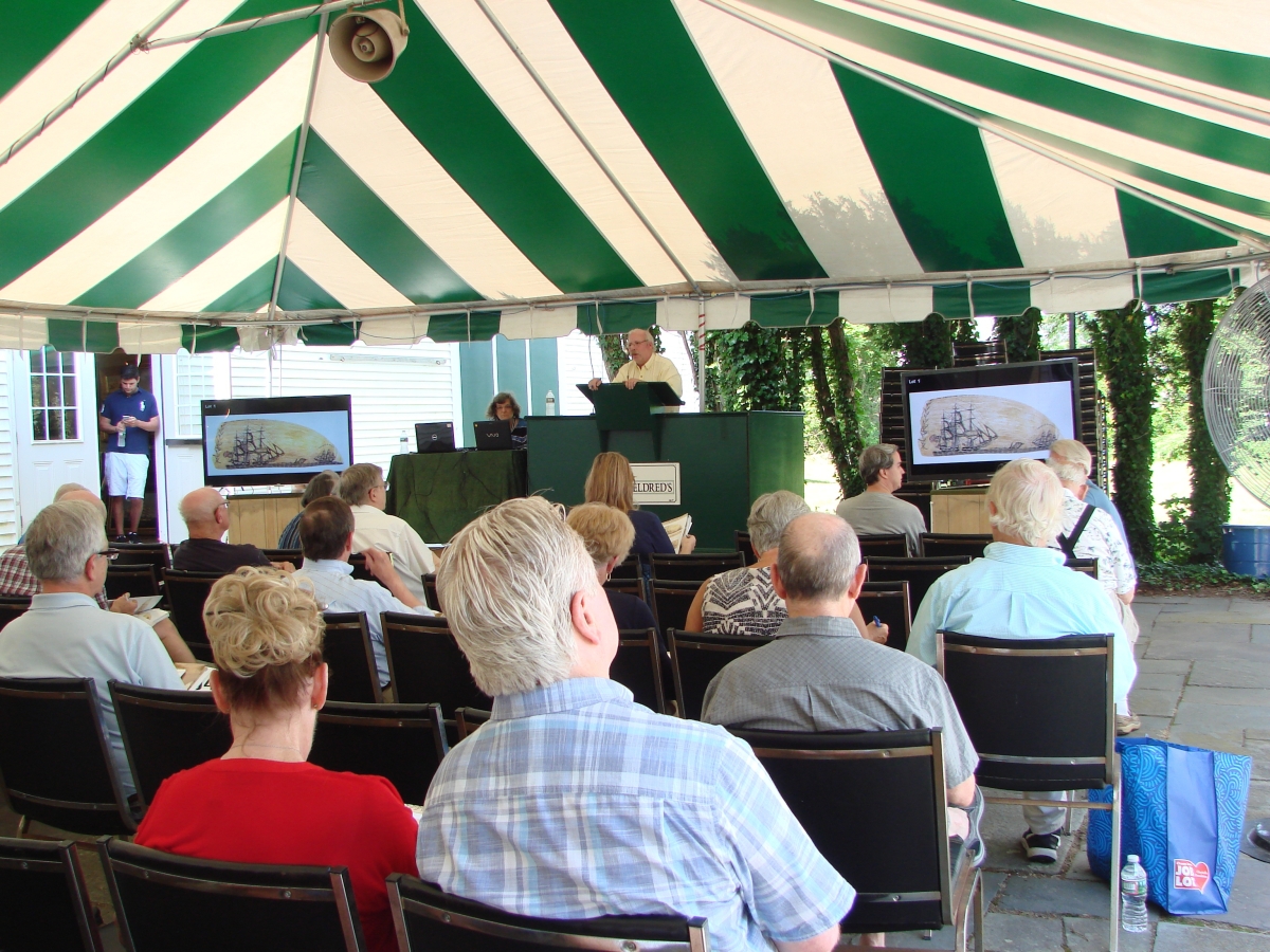 Bill Bourne, vice president of Eldred’s, starts off the auction with the record-setting Burdett tooth.