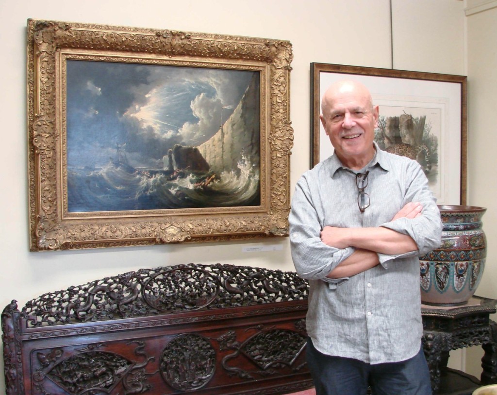 Carl Nordblom stands near the ornately carved Chinese settee.