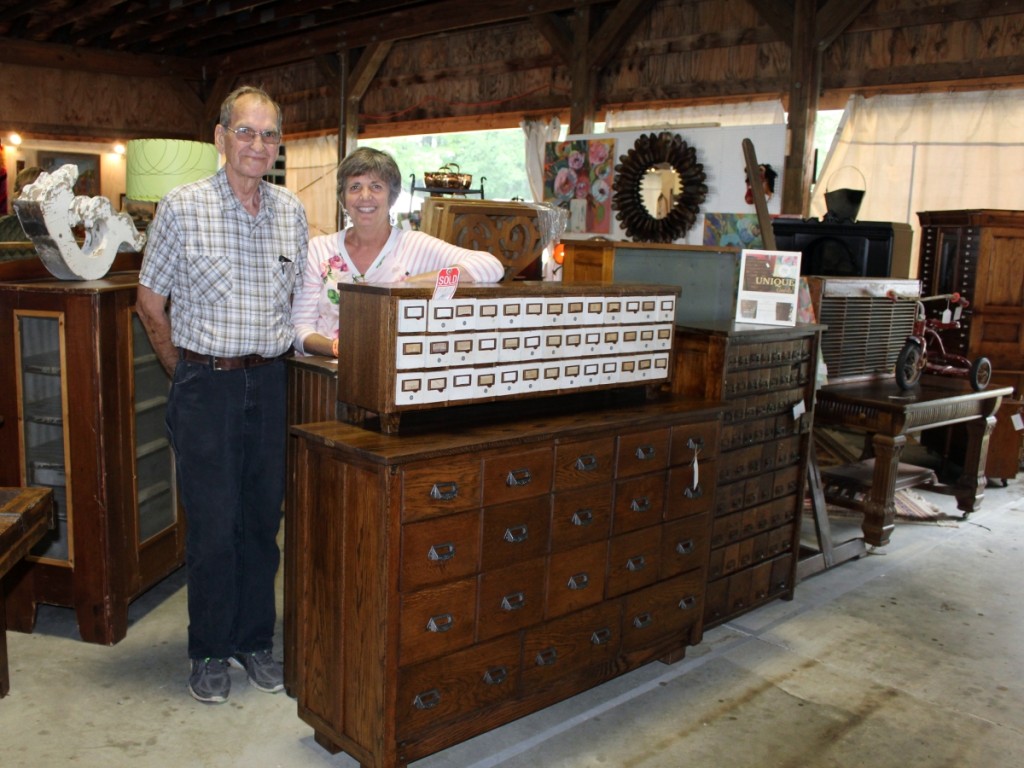 Ken Bailey and Tressa Mills stand proudly with some of the furniture pieces they have reclaimed as Finders Keepers, Holland, Mich. The hardware cubbies on top, for example, are late 1920s. Ken replaced the battered plywood top with rich dark oak, replaced the legs and back and gave them new life.                                                     —New England Motel