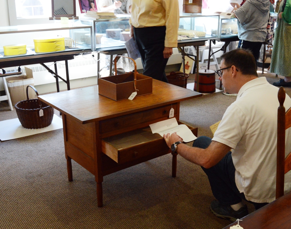 This buyer checks out the McCue’s sewing table in butternut, made for a Sister, that earned $75,000.