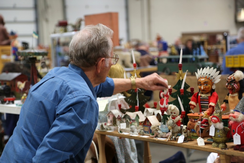 A seller arranges the candles on the Christmas tree.