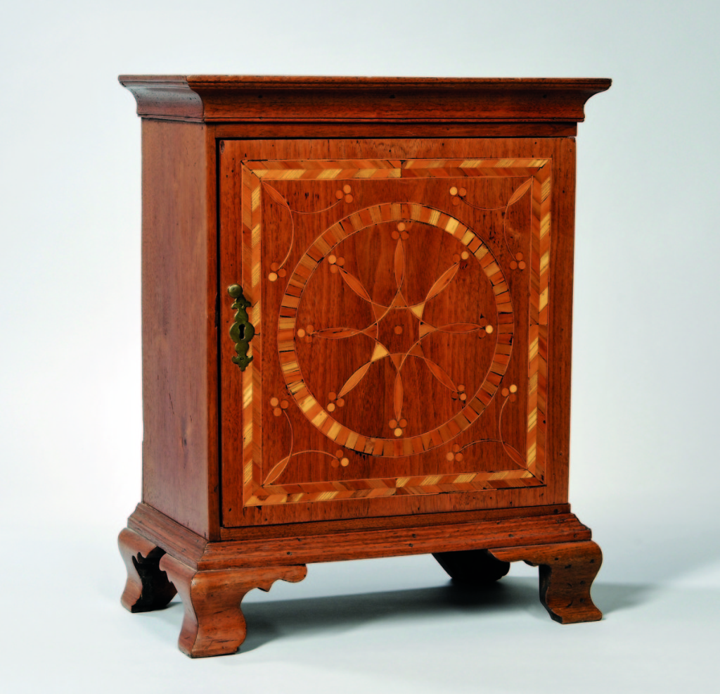 The top selling lot of furniture was this inlaid walnut spice cabinet from Chester County, Pennsylvania, which reached $25,830. The door was inlaid with compass decoration and berries, within a herringbone pattern frame, and the interior had 11 drawers.