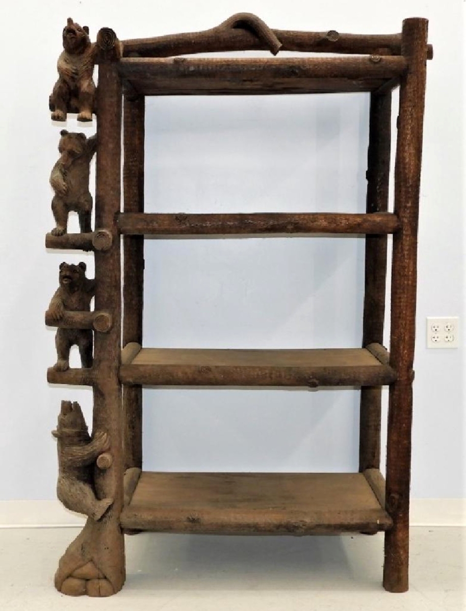 German Twentieth Century Black Forest bookcase shelf, naturalistically carved with timber-form supports adorned with bear cub figures, 72 inches tall, sold at $6,875.