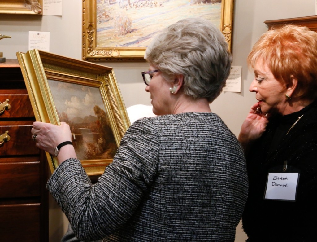 Chester County Historical Society president Elizabeth Laurent takes a closer look at a West Chester river landscape painting signed Geo. Cope, 1884.