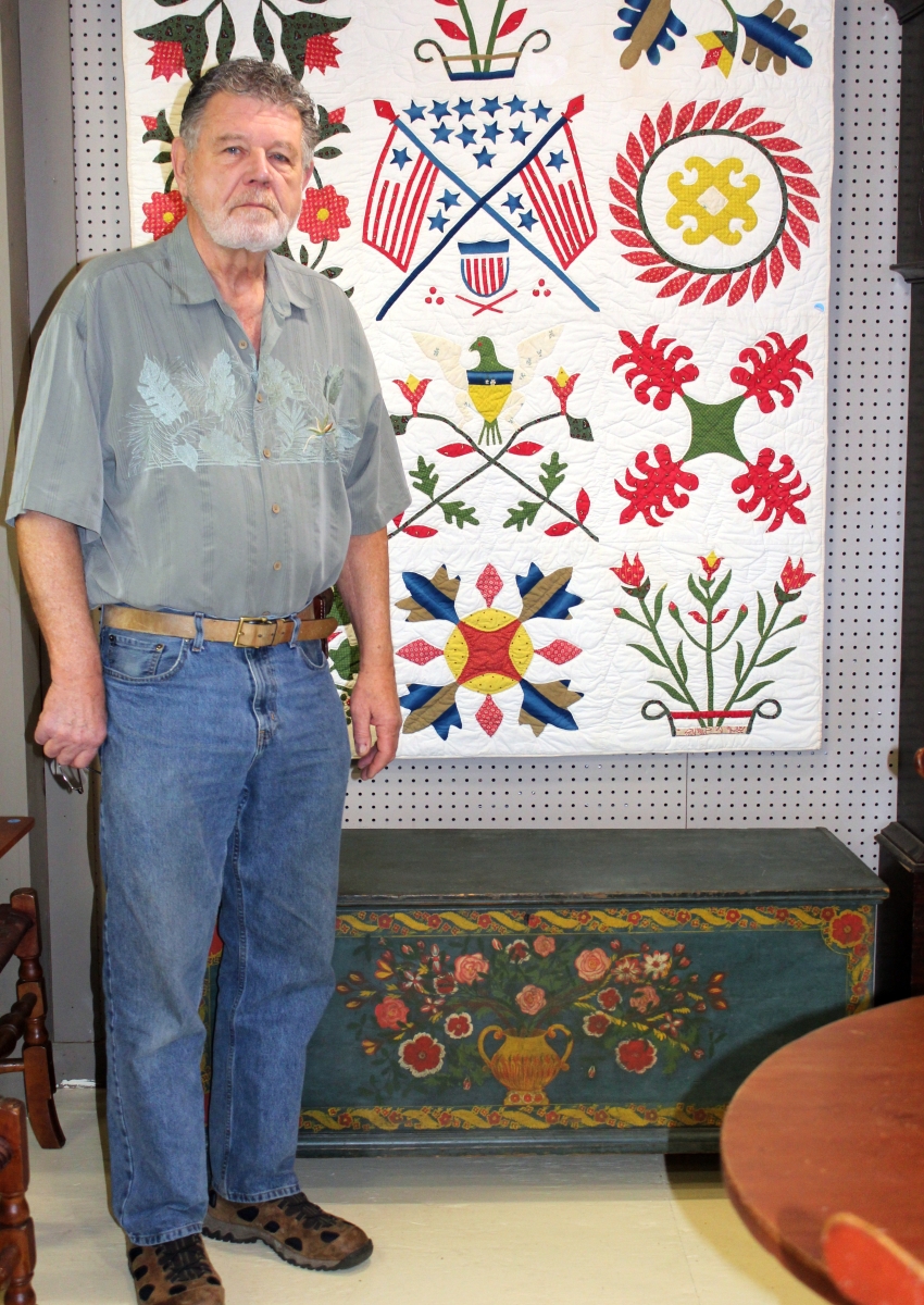 “Buzz” Hesse shown here before the April 29 session started. The Schoharie County painted chest was the top lot, bringing $4,592 to a floor bid, while the Baltimore album “youth” quilt on the wall behind him went to a phone bidder for $4,255.