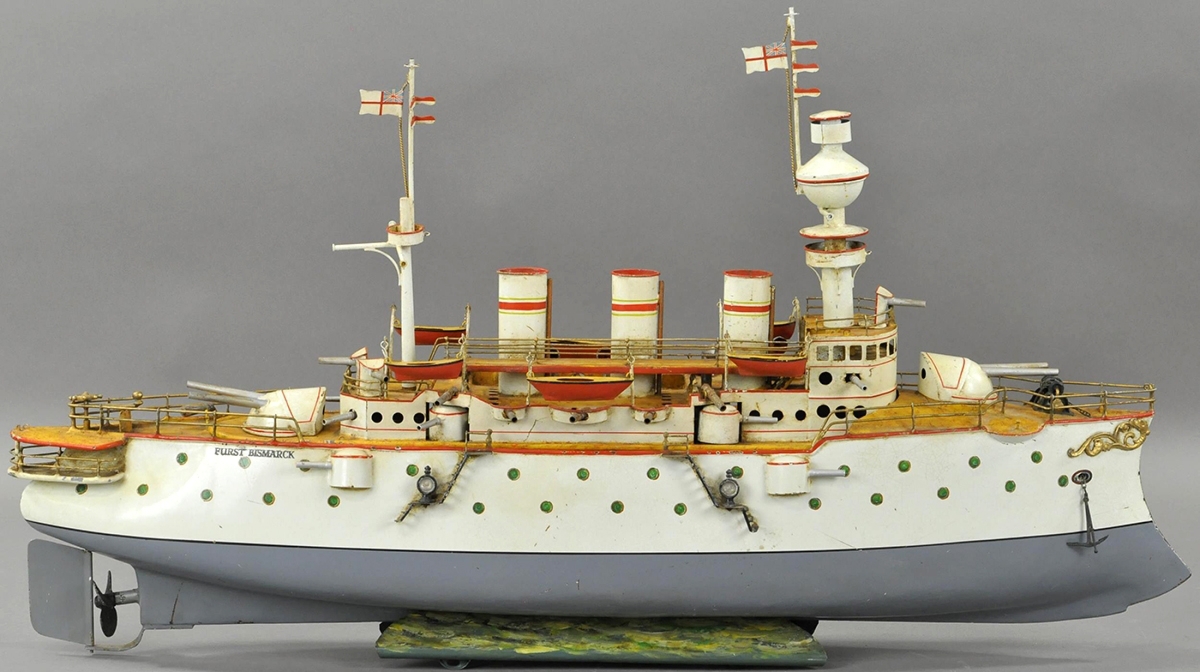 This Bing Furst Bismark Battleship, with three stacks and green portholes, elaborate cast metal decorations on its bow, 32 inches long, sold for $18,000, within estimate. It has been professionally restored and features multiple large cannons and several smaller guns and two detailed masts with British flags and crow’s nest.