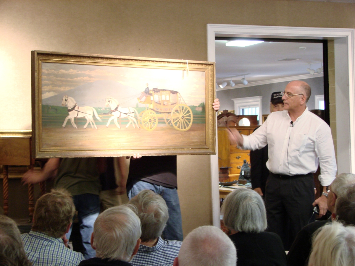 A colorful Concord coach pulled by four white horses, on the road near Claremont, N.H., was depicted with Mount Ascutney in the background. It was painted in 1888 and was accompanied by a cabinet photo of the driver, John McCullough. It is shown here crossing the block with Bill Smith, who would sell it to a phone bidder for $10,925.