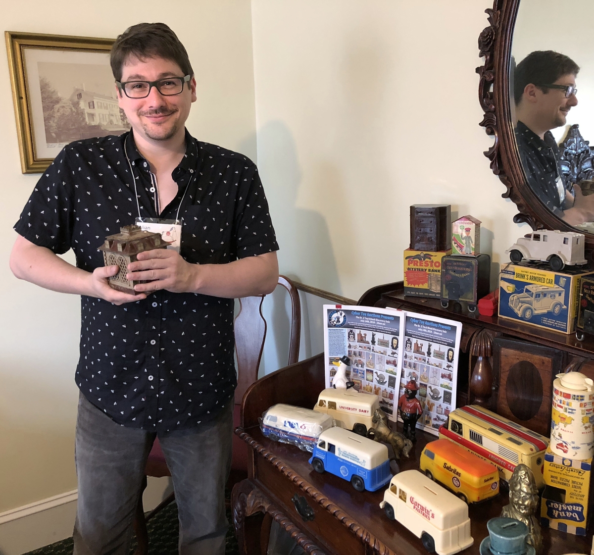 Julian Abernethy, photography and computer specialist at RSL, with a selection of banks and toys arranged in his room.