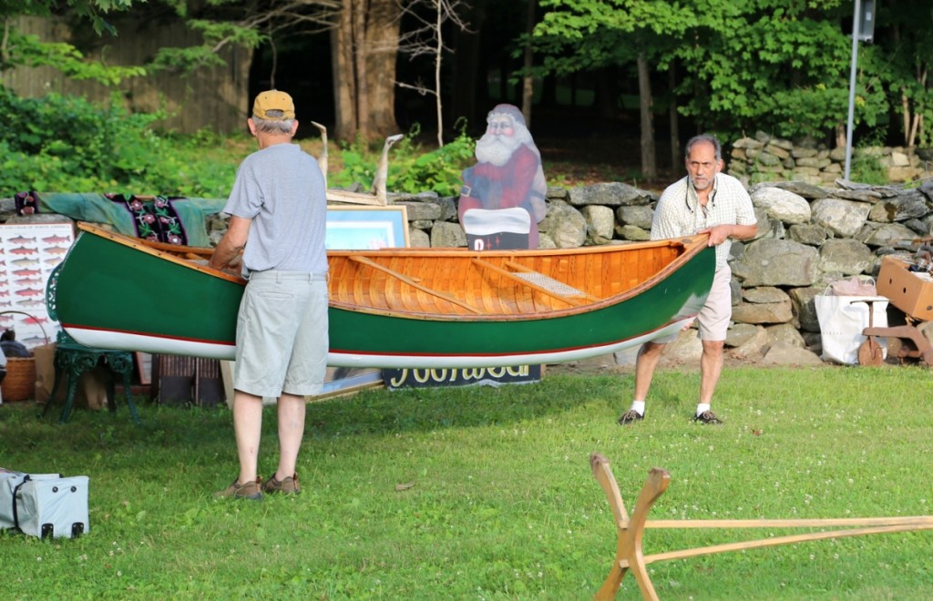 Kenneth Arthur of Spotted Horse Antiques, West Windsor, Vt., enlists Frank Gaglio to set up a nice Adirondack canoe at the front of his booth.