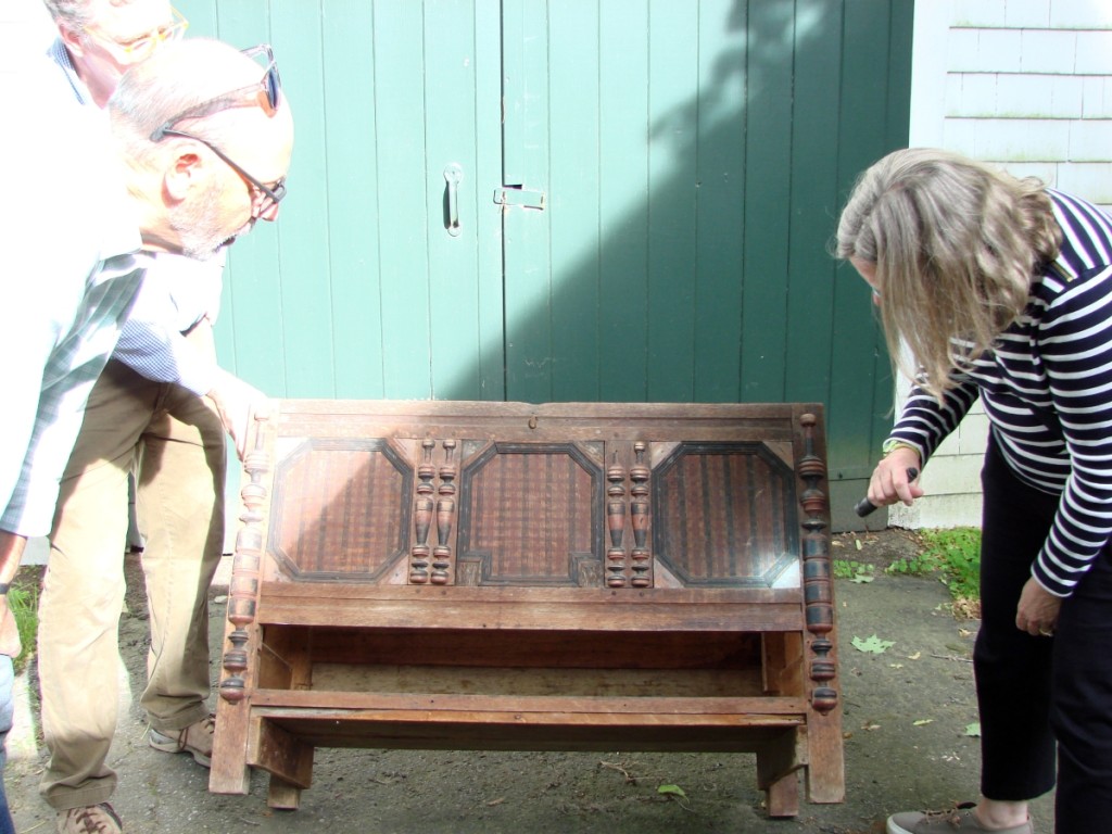 Nancy Carlisle, curator at Historic New England, examined the chest with a flashlight while Clark Pearce looked on.