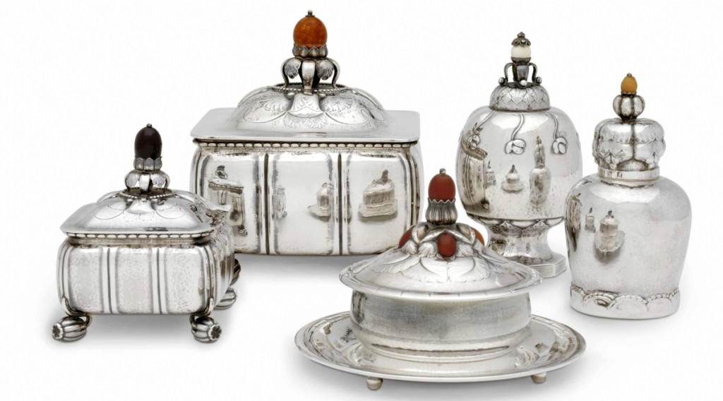 These examples of silver hollowware with nature-based ornament and lightly hammered surfaces illustrate Georg Jensen’s own roots in the Arts and Crafts style. Box, tobacco caddy, butter dish and tea caddies, models 30, 30C, 44, 46 and 137, by Georg Jensen, designed 1912–14. Lent from a personal collection.