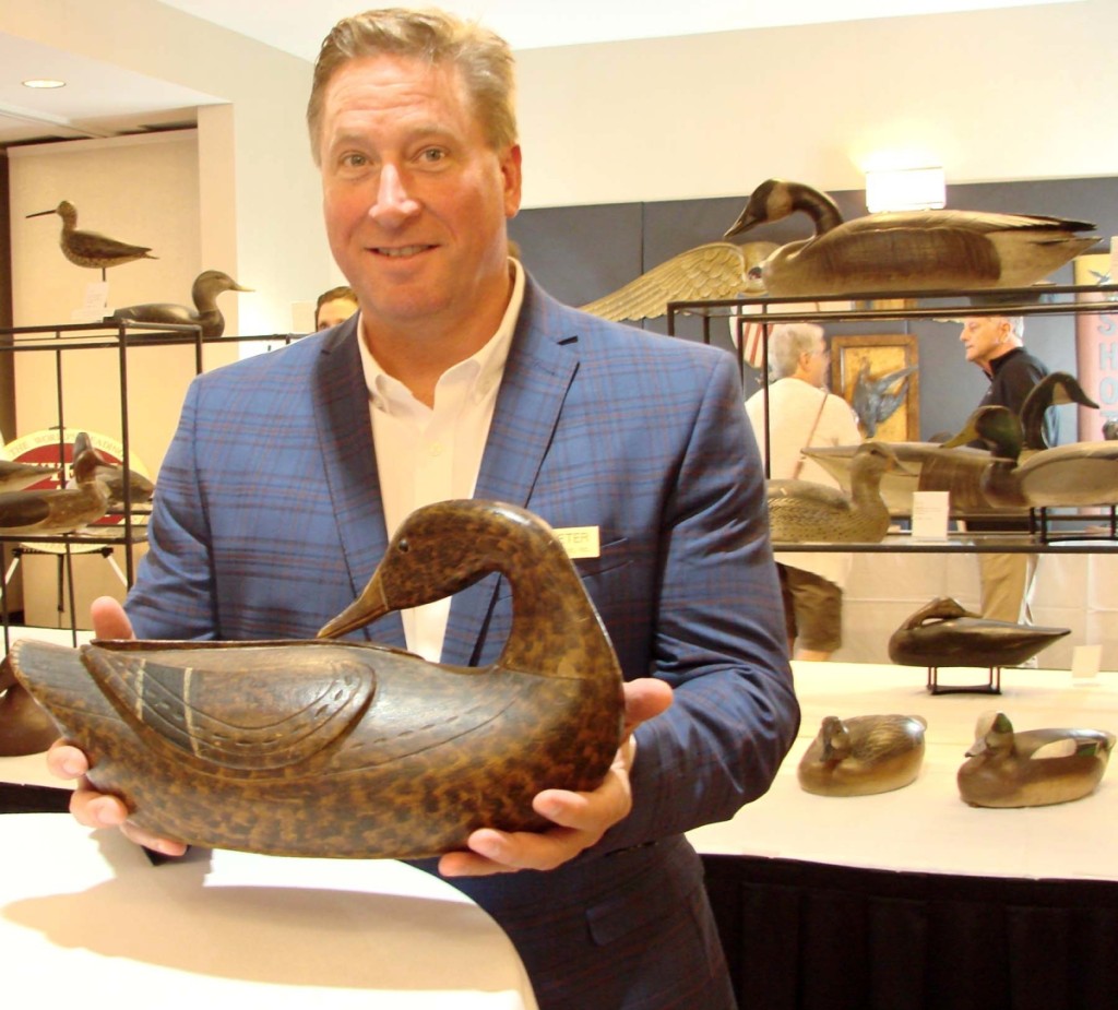 Jon Deeter smiles during the preview, as he holds the $767,000 Caines Brothers mallard hen, which was the top selling decoy.