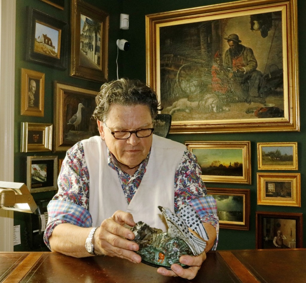 Kaja at work in his office, examining a mechanical bank.