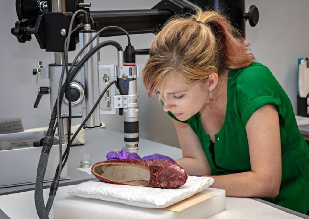 Dawn Wallace, a conservator for the Smithsonian Institution’s National Museum of American History, analyzes one of the recovered slippers at the Smithsonian’s Conservation Lab in Washington, DC. (Smithsonian photo)