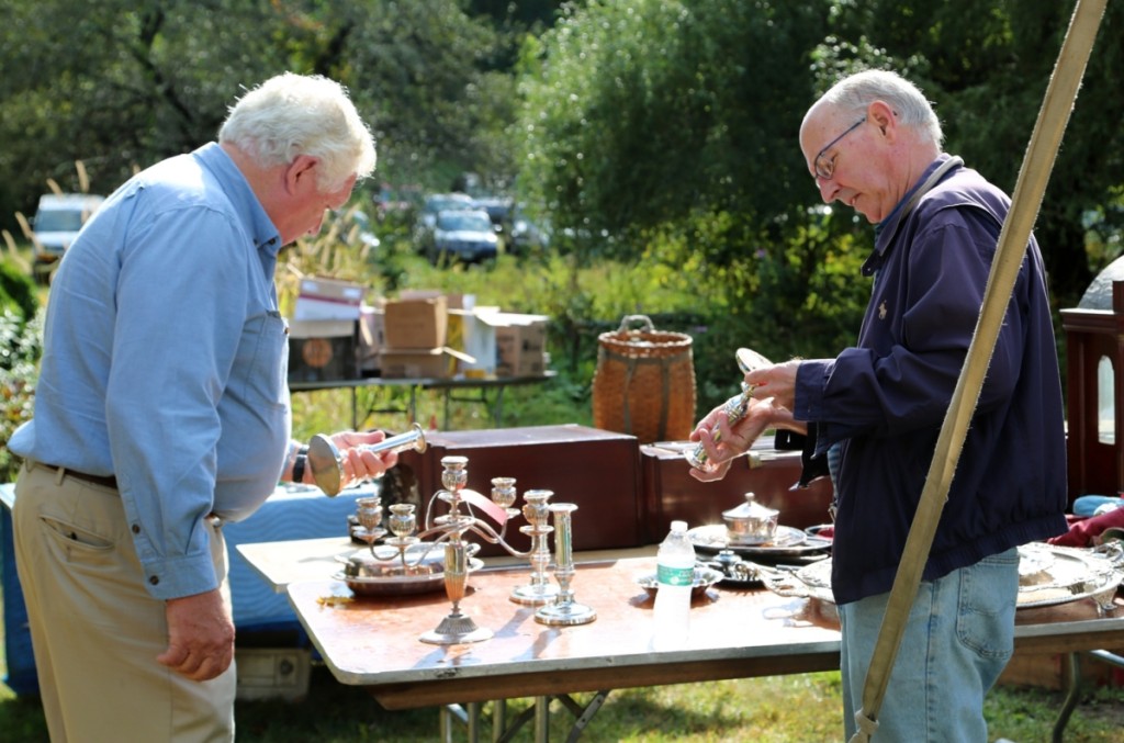 A couple of buyers take a look at some of the weighted silver candlesticks on the tables outside the tent.