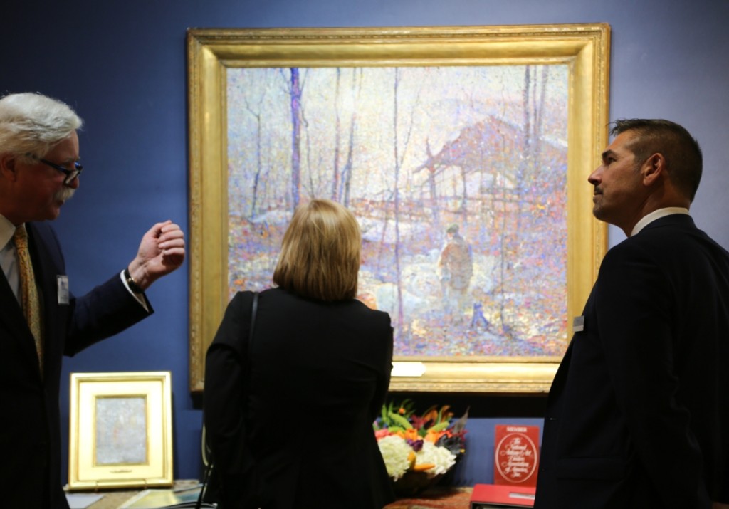 Newport, R.I., dealer William Vareika stands to the left as visitors admire “Sunrise,” an oil on canvas painting by American artist John Costigan.