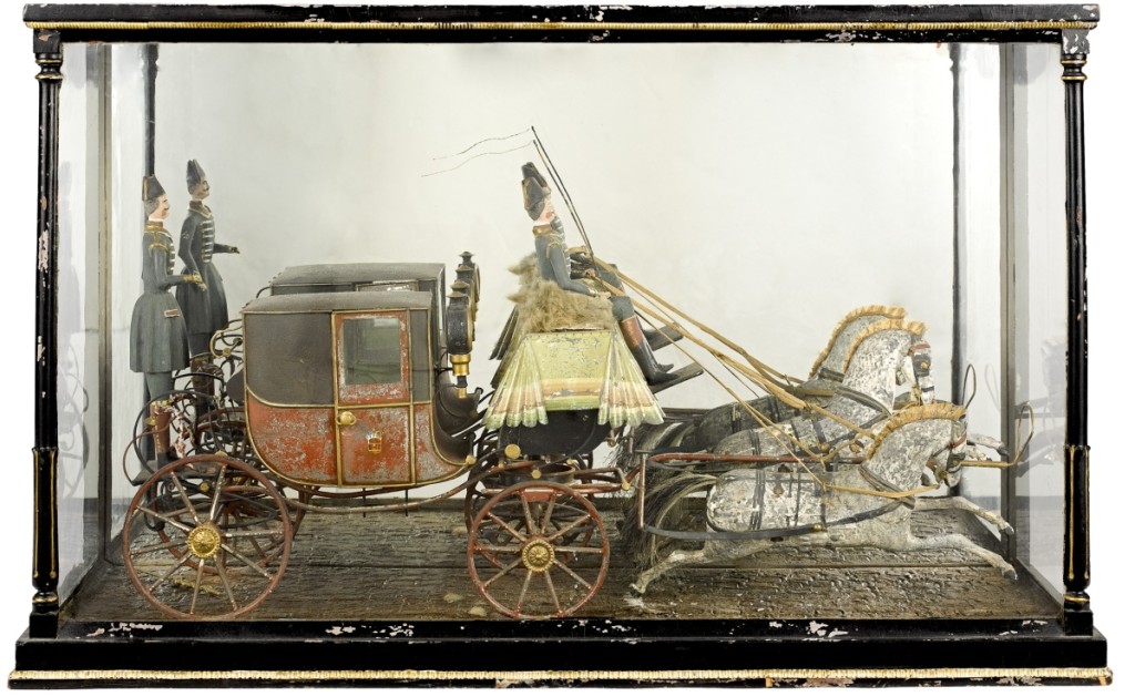 In a glass display case was an English painted tin and wood horse-drawn royal coach model, Nineteenth Century, with two wooden horses, driver and rear guard. It sold over the $1,600 high estimate for $4,148.