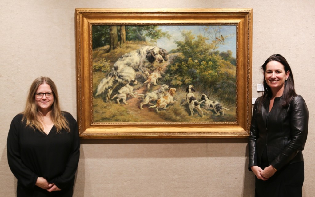 Sales specialist Shani Toledano, left, with Doyle’s newly minted chief executive officer, Laura K. Doyle. Both stand around the top lot of the sale, Edmund Henry Osthaus’ “The First Lesson — A Setter and Her Six Pups.” The 30-by-40-inch oil on canvas took $62,000.
