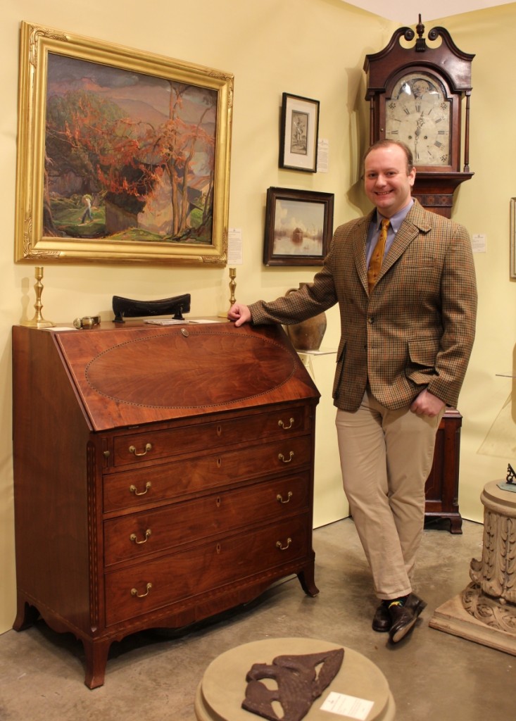 Taylor Thistlethwaite sold an early Baltimore chair on opening night and a Civil War sword during the show. He is shown here with a Federal inlaid walnut slant-lid desk from western Maryland that he found in Kentucky. Hanging above the desk is a western Maryland painting done by Gladys Nelson Smith. Thistlethwaite Americana, Alexandria, Va. and Glasgow, Ky.