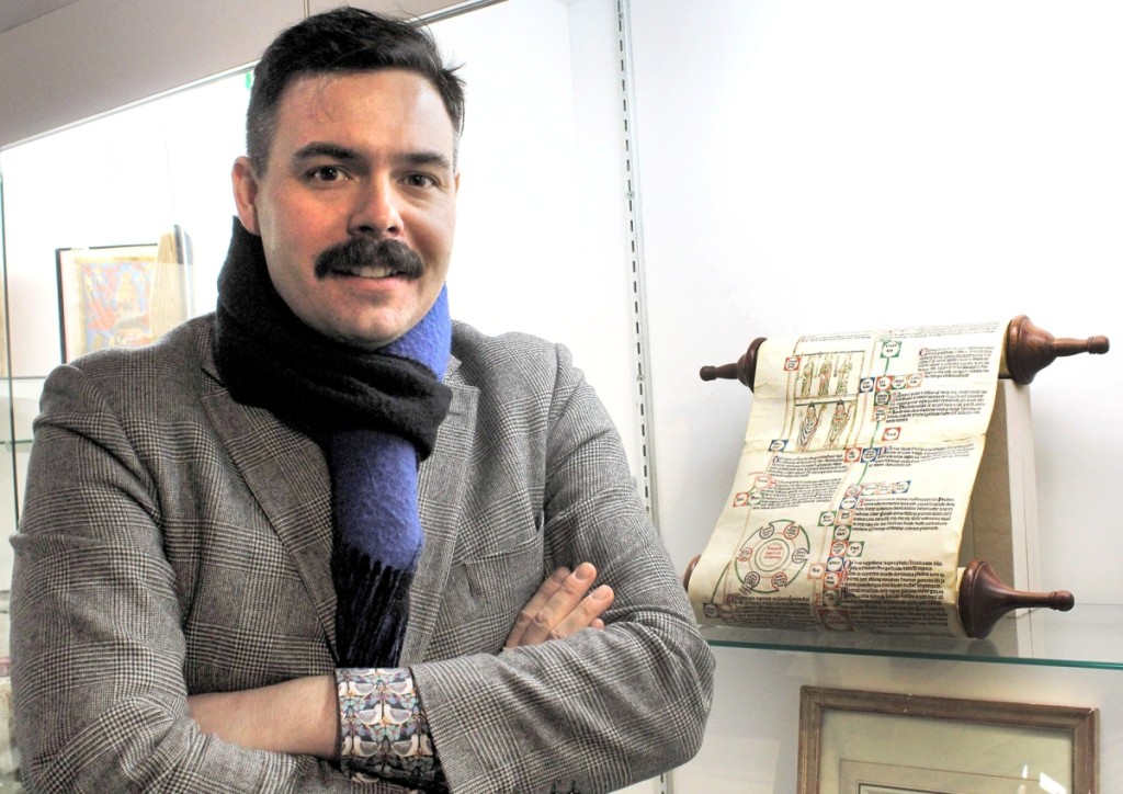 Les Enluminures vice president Keegan Goepfert stands next to a Thirteenth Century illustrated scroll summarizing biblical history from Adam to Christ. The last known example in private hands, it is 3 meters long when unfurled.