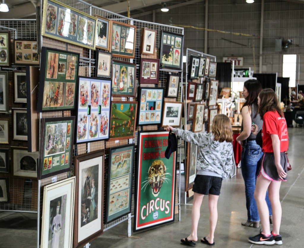 A young visitor finds intrigue in a presentation picture offered from A La Carte Art.