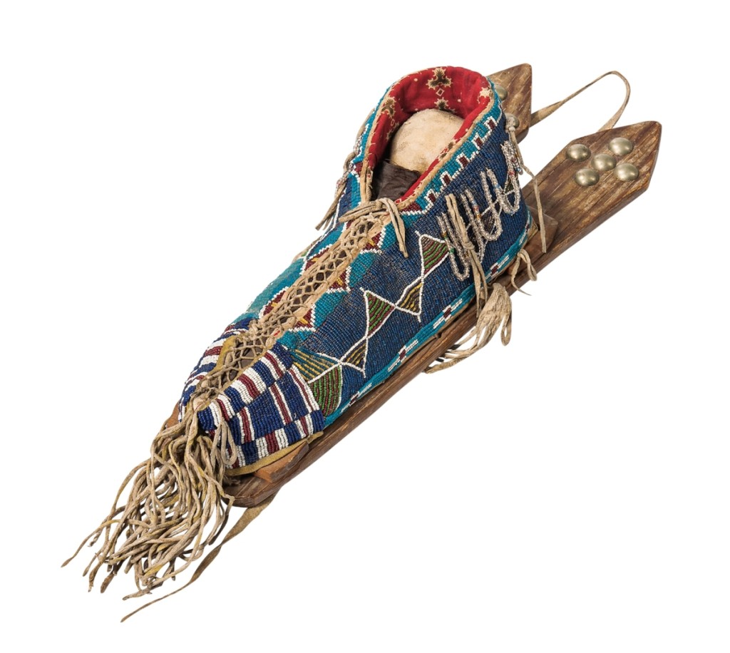 A piece of ART, with capital letters, and the highest priced beadwork item in the sale, this colorful Kiowa beaded cloth and hide model cradle, in various shades of blue, circa 1890, sold for $19,680.
