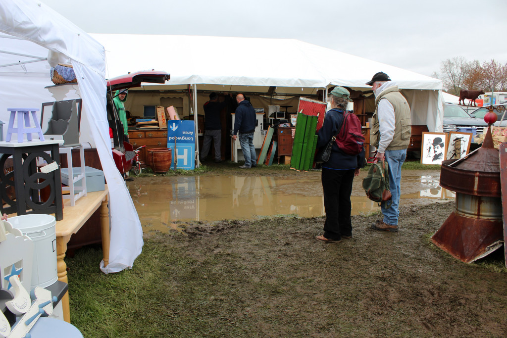Ponding was not an infrequent sight on Brimfield’s opening day, but visitors were generally dressed for the mud and chilly temperatures that accompanied it. -Midway. 