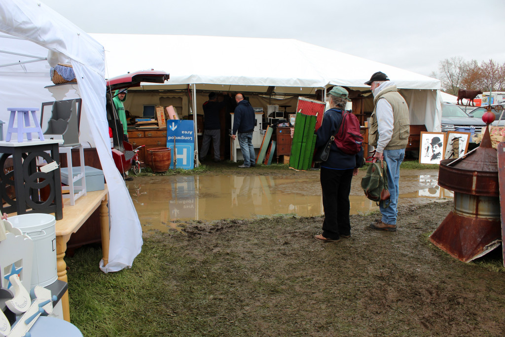 Ponding was not an infrequent sight on Brimfield’s opening day, but visitors were generally dressed for the mud and chilly temperatures that accompanied it. -Midway.