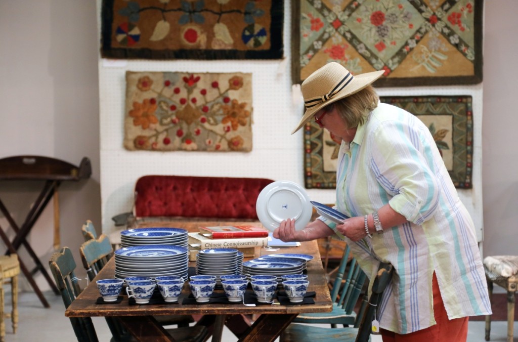 A previewer takes a look through a 74-piece Mottahedeh porcelain set in the “Blue Canton” pattern. It sold for $1,408.