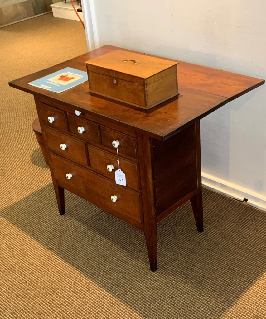 The sewing cabinet had three-over-two-over-one drawers and a pull at the top center that the catalog described as “possibly used to hold individual threads or small sewing implements.” A chalk inscription on the inside of one drawer had the name of Henrietta Morgan, who lived at Hancock and left in 1903. It had been the cover lot in 1984 when it sold for $9,900, with an estimate of $30/50,000. At that time, there was considerable discussion about replaced top, leaf, etc. The biggest question was the pull out in the front to support a nonexisting leaf. Many thought the leaf on the front would get in the way of the drawers, and it has been turned to be on the back. It carried the same estimate 35 years later and sold for $50,430. Over the years, an attribution to Elder George Wright of Hancock has been added. It went to a Michigan collector who passed on it in the earlier sale. He also spent $1,107 for the lift-top box signed with the name of Eldress C. Helfrich, one of the last Ministry at Hancock. It had sold in Henry’s 2014 sale for $2,360 when there was an 18 percent premium.