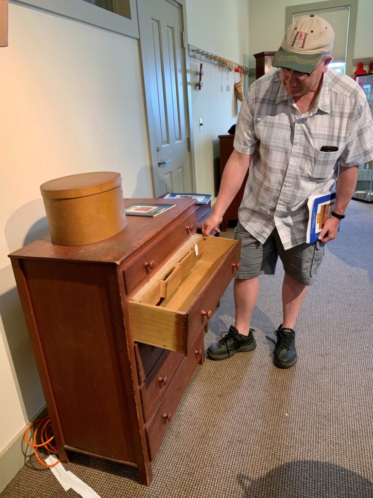 Shaker ephemera dealer Scott DeWolfe from Alfred, Maine, examines the interior drawers in this chest. The piece had been the cover lot in Willis Henry’s first Shaker sale at the Berkshire Hilton in Pittsfield, Mass., in 1982, where it was hammered down for $2,000. This time around, the red chest brought $100 more. But the increase in the added premium meant $2,200 many years ago and $2,583 this time.