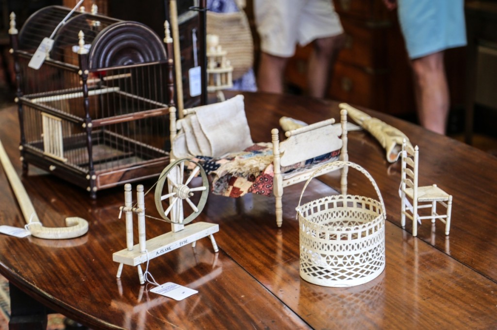 Nearly $40,000 in miniature whalebone works can be seen here. At front is a whaleman-made Nantucket pierced swing handle scrimshaw basket that brought $15,860. The whalebone doll’s bed behind followed closely at $14,640. The spinning wheel to the left was inscribed “A. Clark 1876” and took $6,250. The little chair on the right, a whaleman-made whalebone ladderback rush seat side chair, brought $3,172.