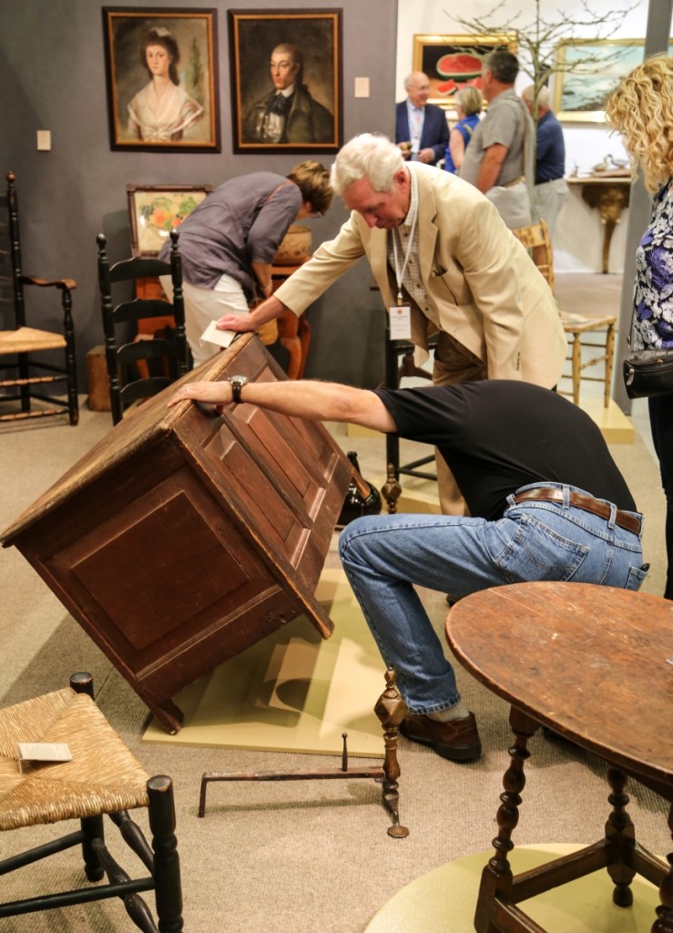 A buyer gets a closer look at Peter Eaton’s Seventeenth Century pilgrim paneled chest in original red wash. It sold opening day.