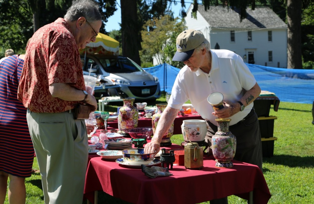 Wearing the Navy baseball cap, Augie Bessinger, Lyme, Conn., is seen discussing Chinese export porcelain with a customer. Bessinger said he has been in the business for about 60 years.