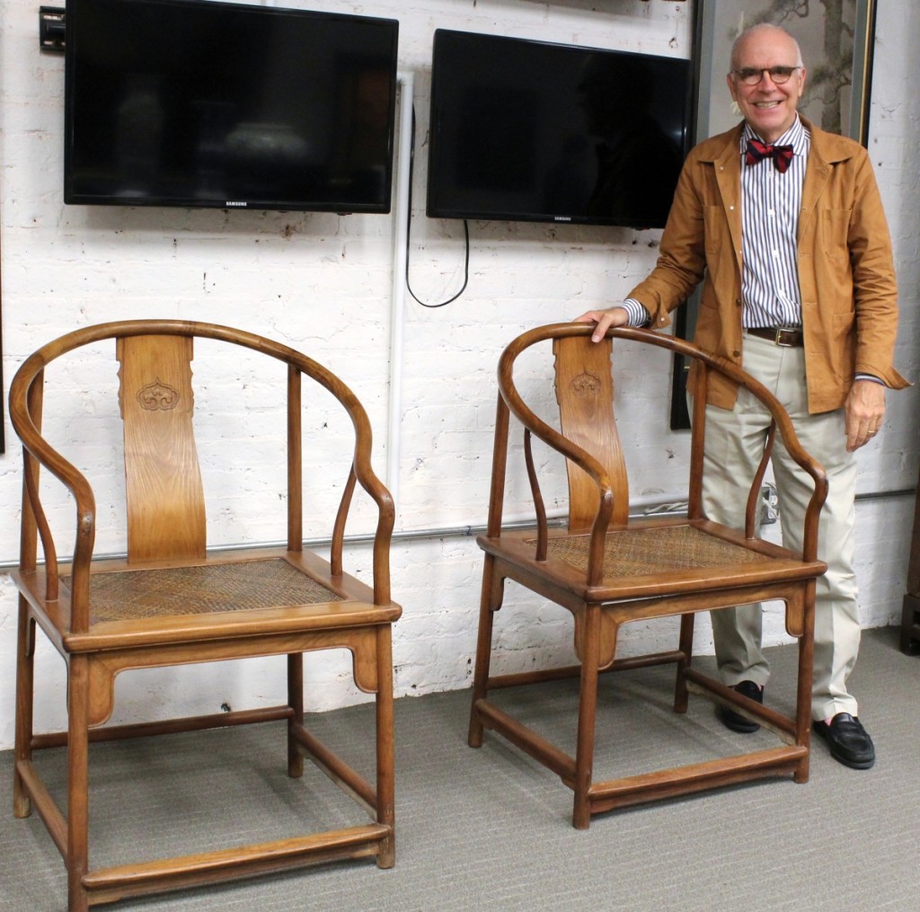 Asian specialist and auction house owner Lark Mason stands with a pair of rare Chinese huanghuali continuous horseshoe back armchairs dating from the early Qing dynasty that were expected to bring up to $900,000 in sales that run through November 5.