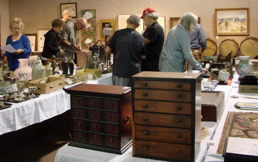 Several prospective buyers examine the merchandise prior to the start of the sale.