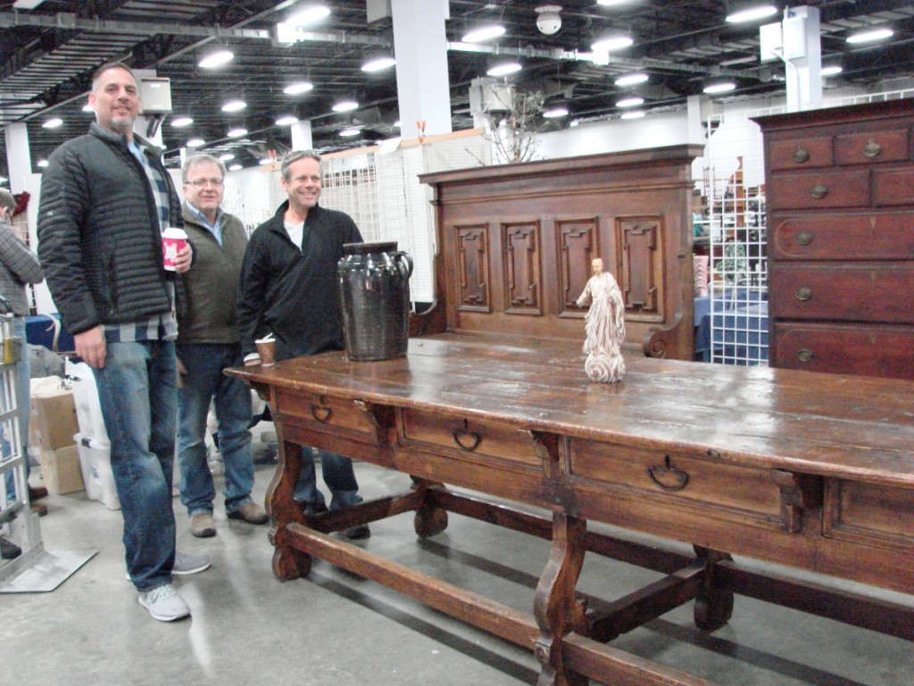 Ian McKelvey on the left and Mario Pollo on the right offering their opinions on the origins of this 11-foot-2-inch-long table to Greg Hamilton. Consensus? Probably Mexican, maybe Eighteenth Century. Wood? — no consensus.