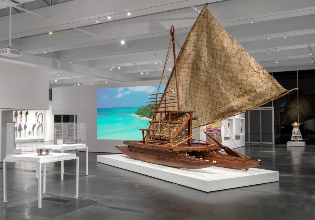 This contemporary drua (double-hulled sailing canoe) was commissioned as a heritage project in Fiji to encourage the retention of canoe-building skills. Joji Marau Misaele managed the project in Fiji with the drua building team — carvers and mat-sail-makers — originally from the islands of Ogea and Vulaga in the Lau region. The team harvested trees from the forests on Ogea and completed the canoe, which has no metal components, using traditional tools, fiber lashings, and shells. The sail is composed of six sections of hand-woven pandanus-leaf matting, which prevents tearing of the entire sail. Without a fixed bow or stern, drua can sail in either direction. In the Nineteenth Century, large double-hulled canoes provided effective open ocean transportation and carried troops in times of war. Installation photograph, Los Angeles County Museum of Art. Photo ©Museum Associates/LACMA.