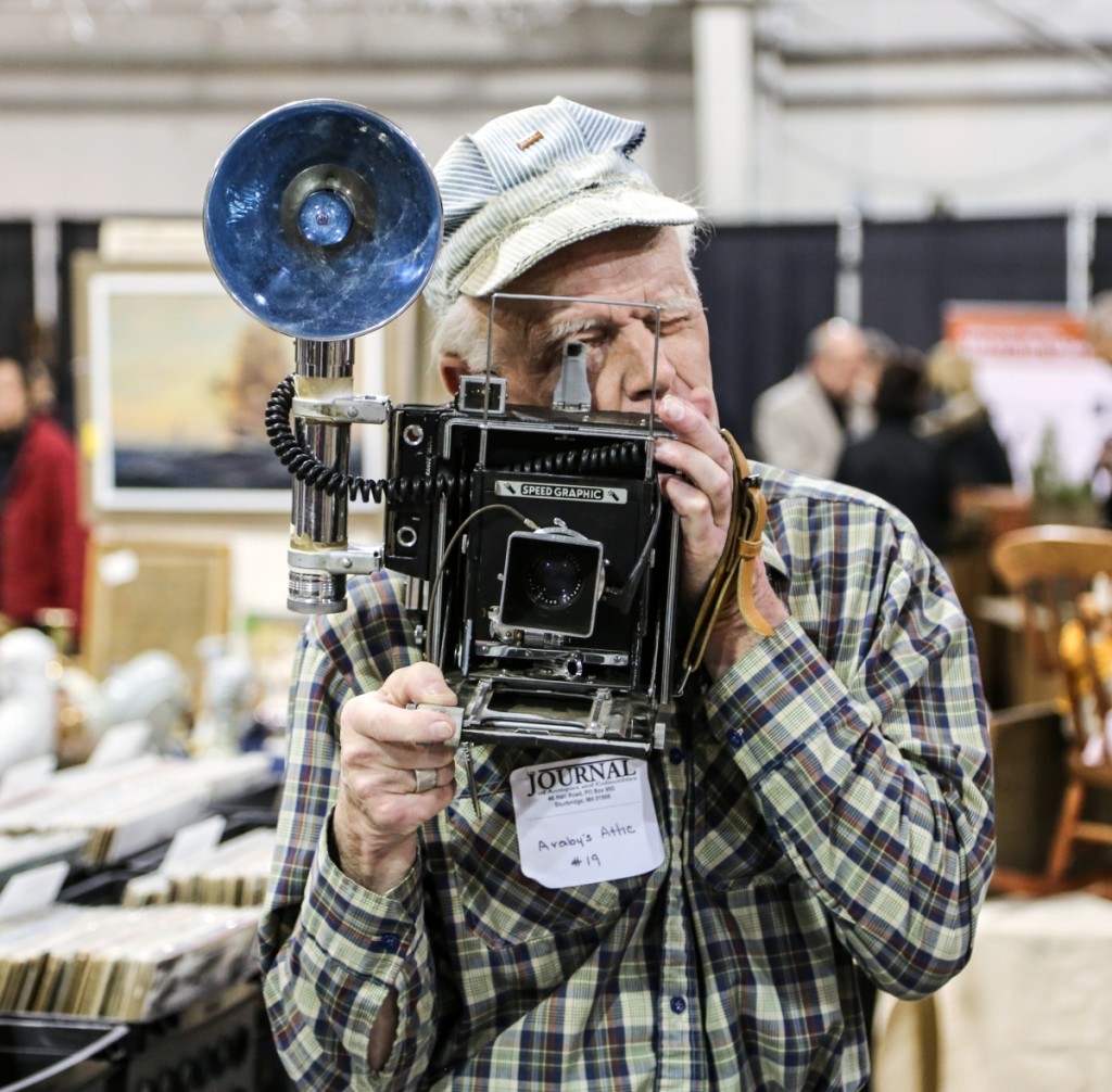 John Hall holds up a 1939 Speed Graphic, produced by Graflex. They were marketed as press cameras, and famed press photographer Arthur “Weegee” Fellig used a similar model. Araby’s Attic, Stafford Springs, Conn.