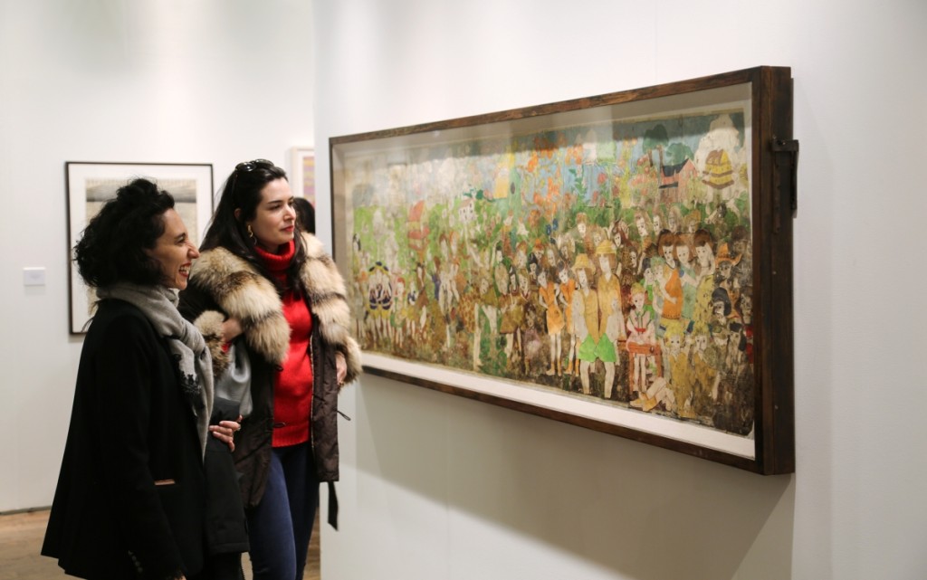 Two women admire the Henry Darger work that sold at Andrew Edlin Gallery, New York City.