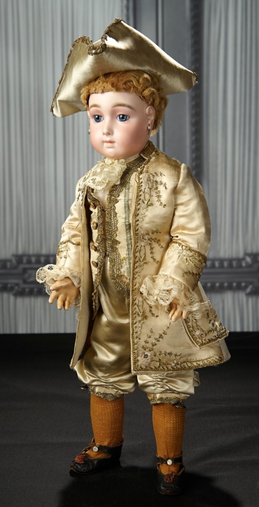 French bisque blue-eyed bebe triste by Emile Jumeau in rare ivory satin Marquis costume ($11/15,000) sold at $39,100.