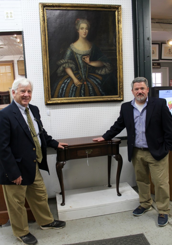 Copake co-owners Mike Fallon, left, and Seth Fallon with one of the sale’s key lots, a rare Eighteenth Century Queen Anne turret top card table. There were close to ten competitive bids on the piece. “We’re happy that it went to a Midwest collector on the phone,” said Mike.