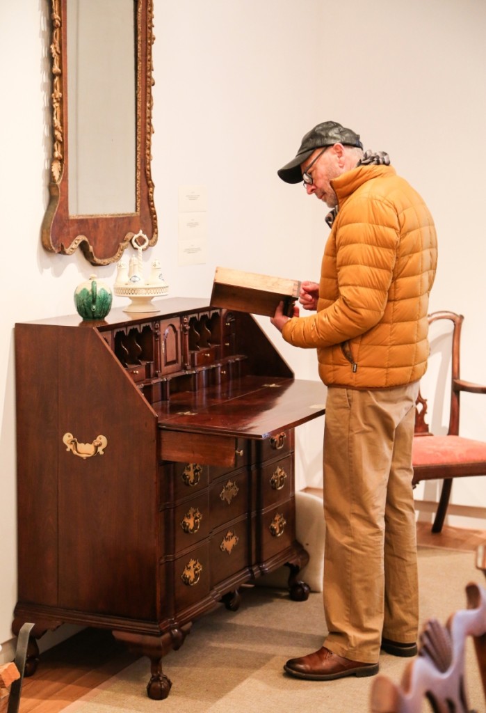 A previewer takes a good look at the Chippendale block front desk from Salem, Mass., which went out at $28,125.