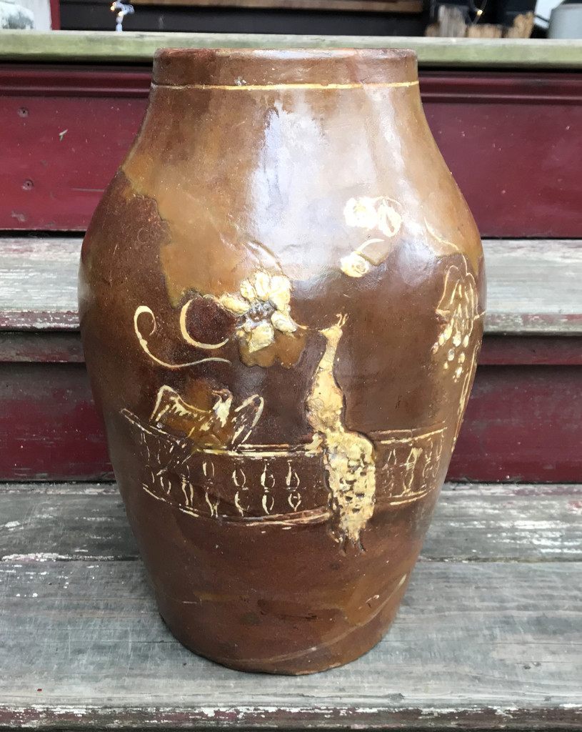 Nineteenth Century slip-decorated red earthenware jar adorned in flowers, eagles and a peacock. 