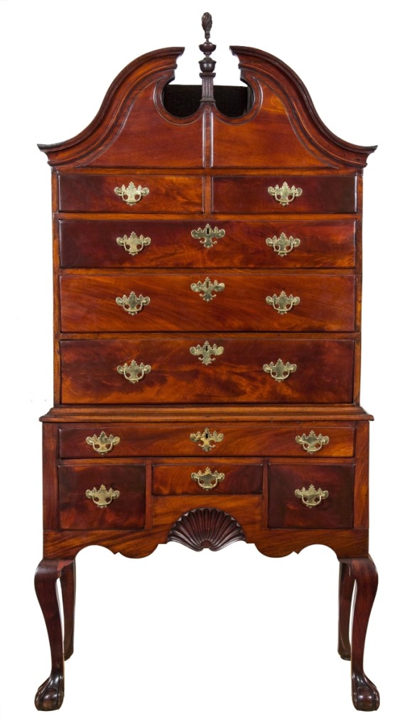 An early Chippendale mahogany bonnet-top   highboy with original finial, Newport, R.I.,   circa 1765, by the Townsend/Goddard School   of cabinetmakers.