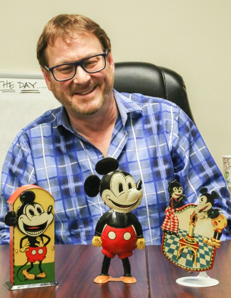 Sale specialist Tommy Sage Jr sits behind $126,075 worth of Mickey Mouse toys from the collection of Jeff Landes. The sale’s top lot sits at center, a German tin-litho windup Five Finger Mickey Mouse toy, which sold for $64,575. The result is an auction record for the model, besting the only other record that had ever been offered before. Sage believes it was made by Saalheimer & Strauss for the English market and it was in excellent condition. To the left, also by Saalheimer & Strauss, is a Mickey Mouse tin-litho mechanical bank that brought $35,670. On the right is a rare tin-litho Mickey Mouse and Felix the Cat sparkler toy, which is only one of a few prewar examples known. It was made in Spain by Rogelio Sanchiz for his company La Isla and was manufactured before 1936. The sparkler doubled estimate to sell for $25,830. Nearly all of Sanchiz’s toys were unlicensed by Disney and they remain some of the rarest in the field.